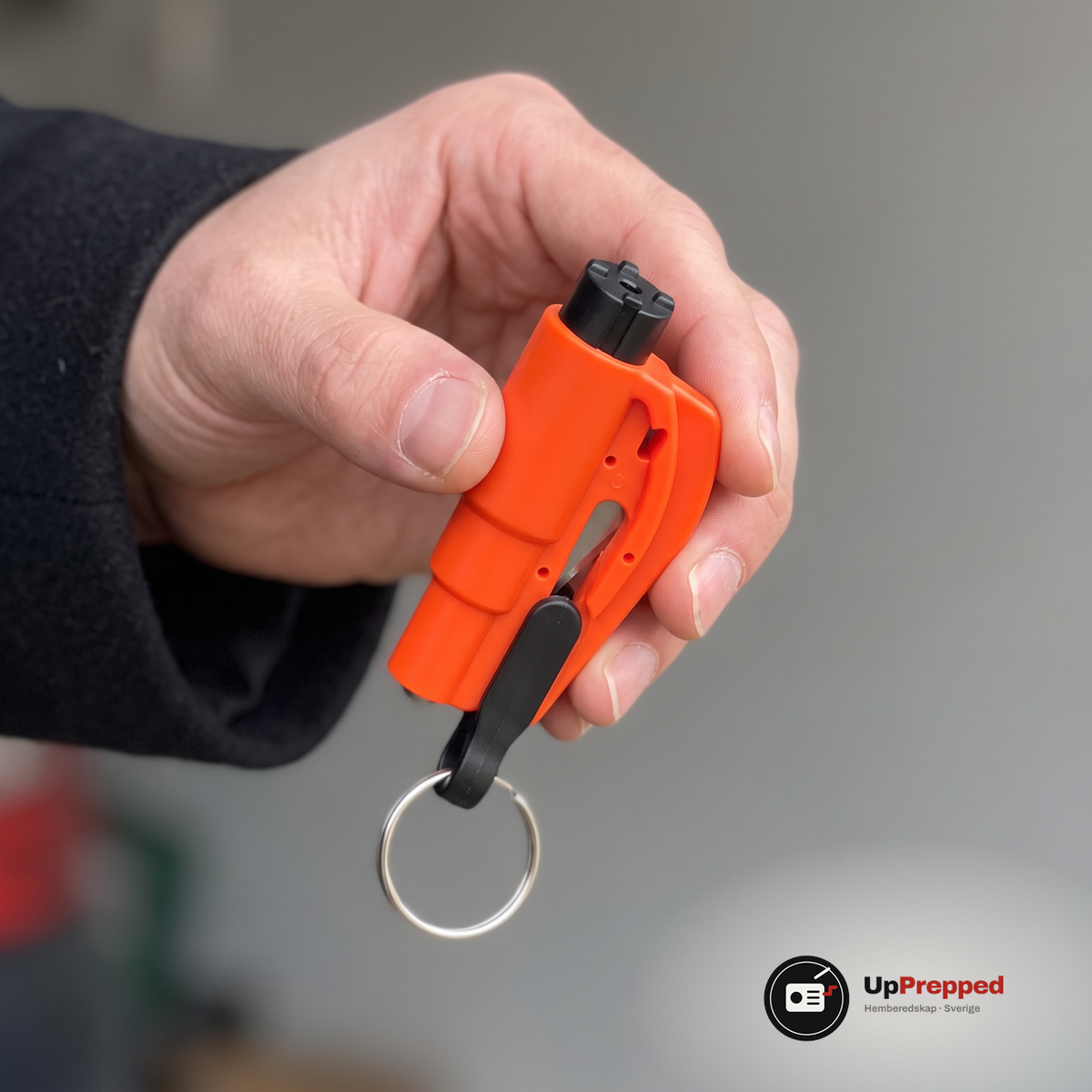 Hand som håller det orange verktyget med det svarta huvudet och dess fyra små knoppar vänt mot kameran