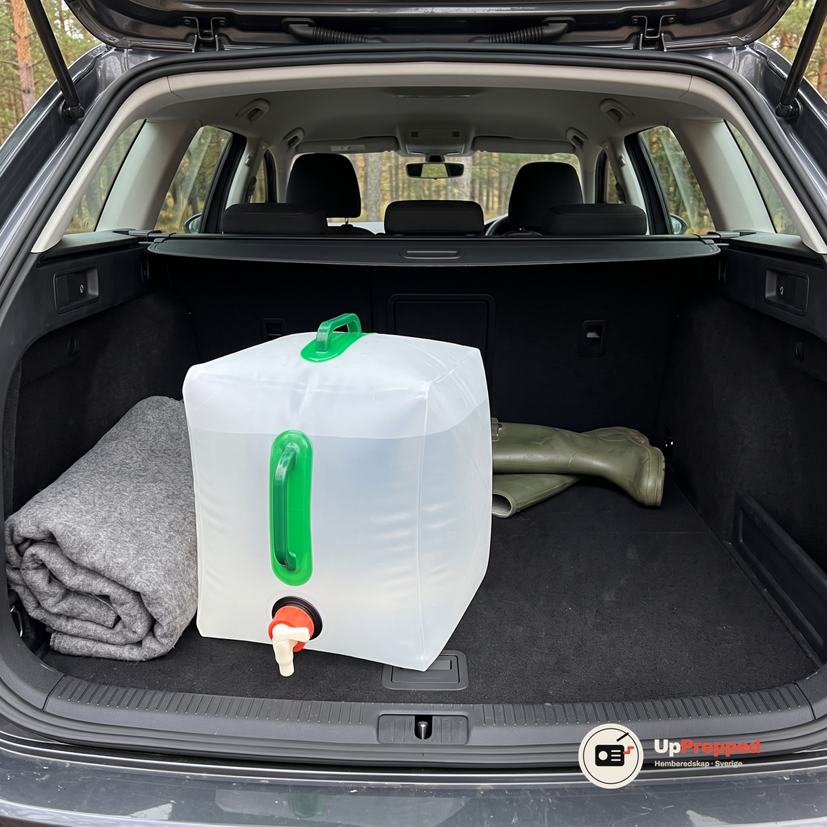 Vattendunk på 20 liter i bagageutrymmet på en kombi bredvid en filt och ett par gummistövlar