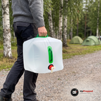 Man bär en fylld vattendunk i det gröna handtaget på en grusväg på en campingplats