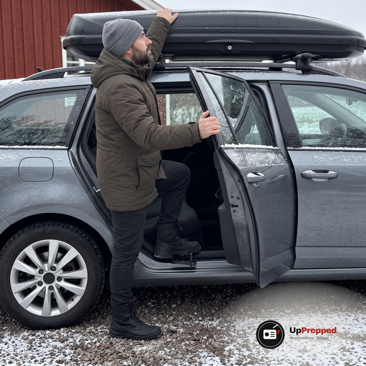 Man med grå mössa och olivgrön jacka står med ena foten på fotsteget vid en öppen bakdörr på en grå kombi och lägger handen på en takbox