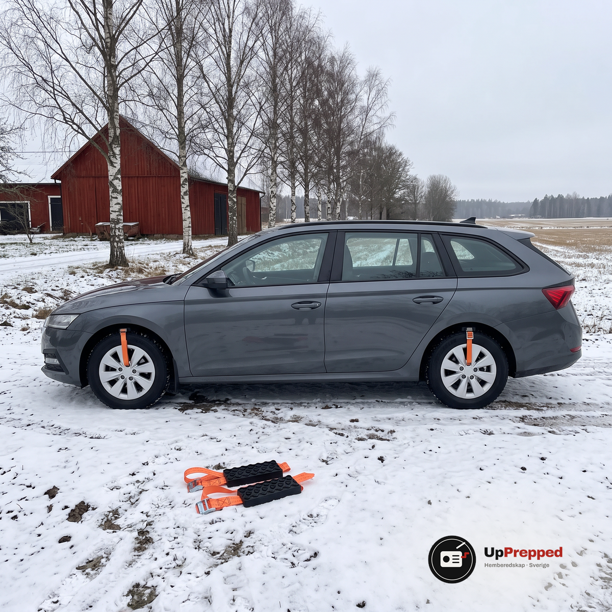 Kombi på en snöig gårdsväg med hjulbroddar fastspända på två hjul och två hjulbroddar utlagda på snön nedanför bilen