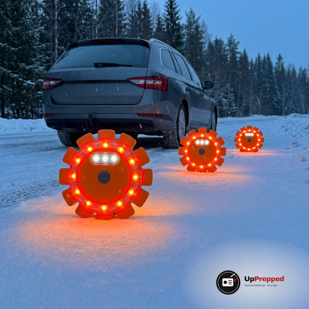 Tre orange LED varningsljus står på rad på en snöig väg bakom en parkerad bil i skymningen
