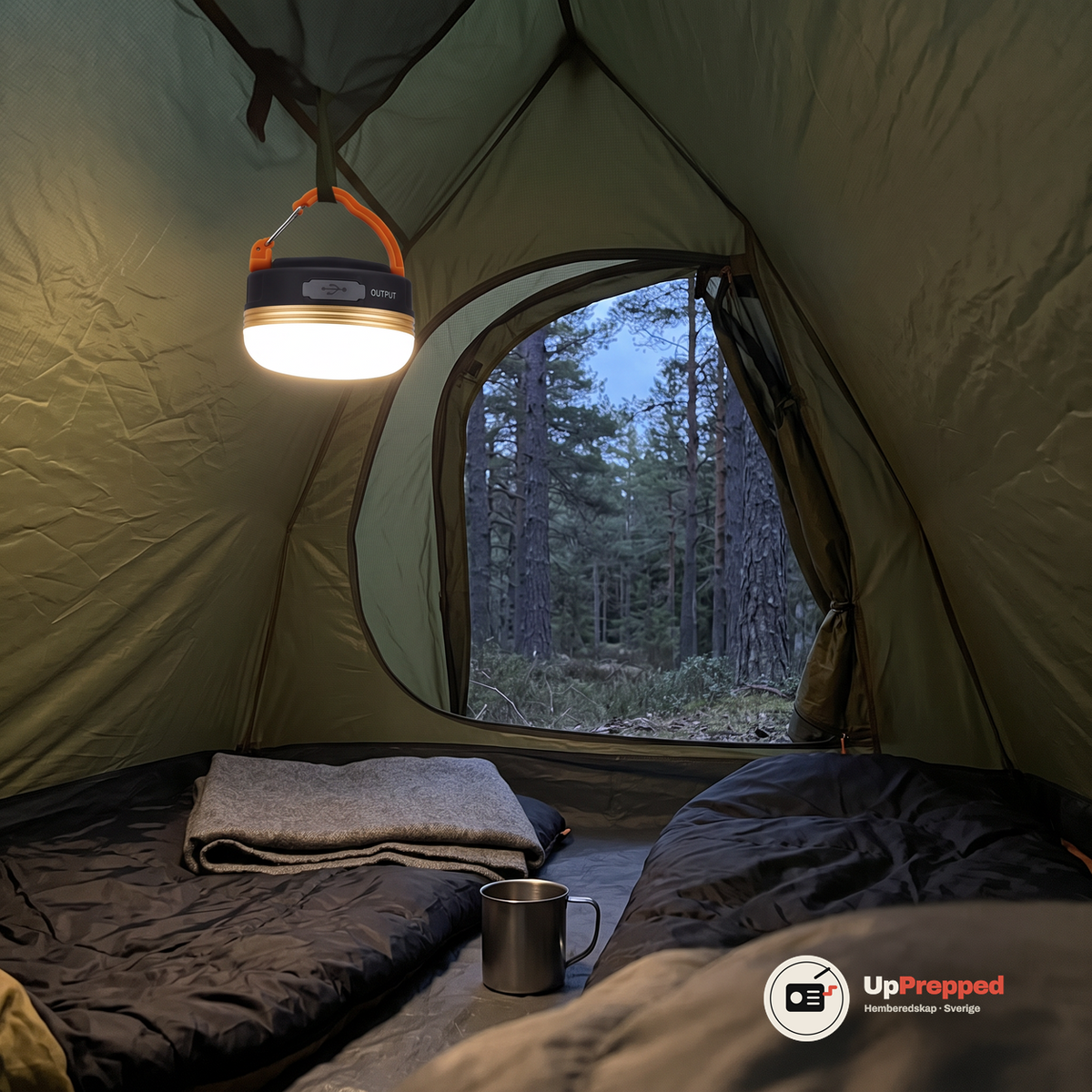 Tänd LED campinglampa hänger i taket i ett olivgrönt tält med skog i skymning utanför tältöppningen