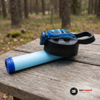 Reservfiltret fastsatt under flaskans svarta lock på ett träbord i skogen. Flaskan och locket ingår inte, bilden visar filtret i vår vattenflaska med inbyggt filter 650 ml