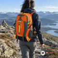 Kvinna går på en bergsrygg i fjällen med orange vandringsryggsäck 40L på ryggen