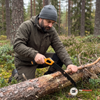 Man i olivgrön jacka sågar av en torr gren över en stock med den utfällda campingsågen i en svensk tallskog