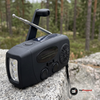 Närbild på nödradions vev, antenn och solpanel på en granithäll i skogen