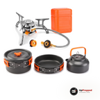 Stormkök med kastrull med lock, stekpanna, vattenkokare och hopfällbar gasolbrännare med flätad slang, adapter och orange box på vit bakgrund