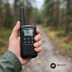 Hand som håller en walkie talkie på en skogsstig för att visa storleken